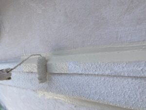 ローラーで白く塗られる外壁