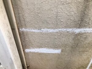 武蔵野市 ヒビを修繕されている途中のクリーム色の汚れた外壁