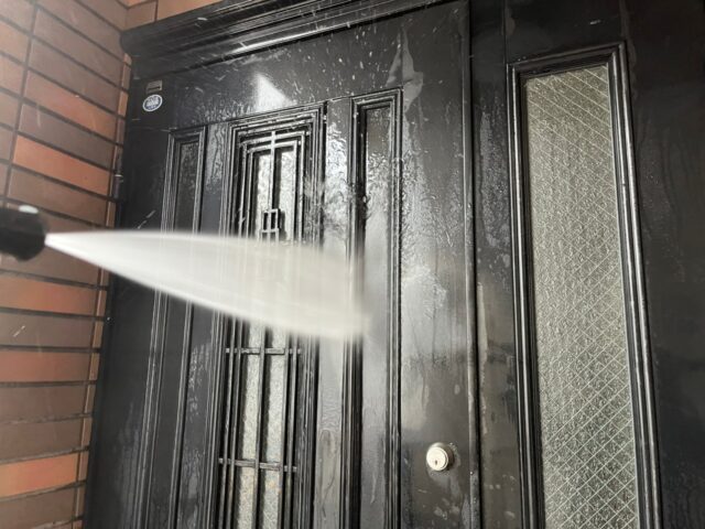 高圧洗浄される調布市の住宅のドア