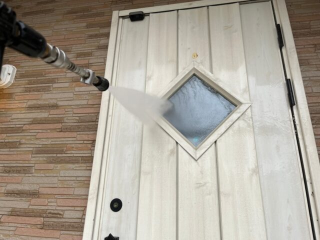高圧洗浄される三鷹市の住宅のドア