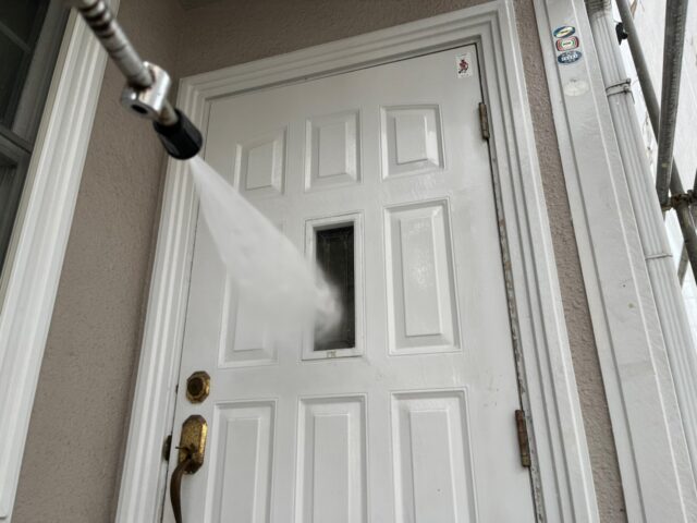 高圧洗浄される三鷹市の住宅のドア