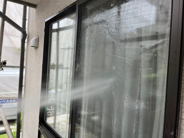 高圧洗浄機で洗浄される三鷹市の住宅の窓