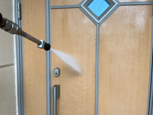高圧洗浄される三鷹市の住宅の玄関ドア