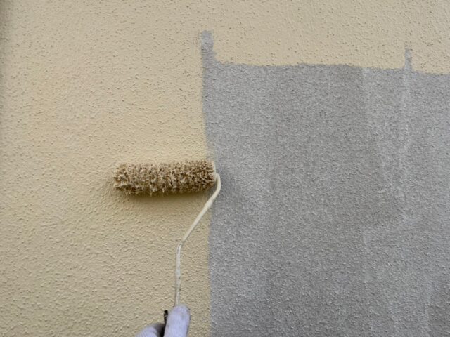 ローラーで丁寧に塗装される世田谷区の住宅の外壁