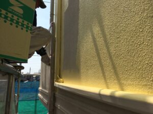 世田谷区黄色のペンキをローラーで塗装する職人さん