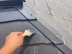 屋根にグレーのペンキを刷毛で塗装