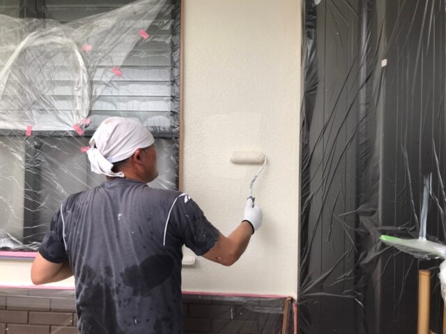 ローラーで白く塗装される三鷹市の住宅の外壁