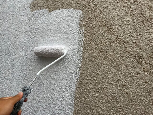 ローラーで丁寧に塗装される三鷹市の住宅の外壁