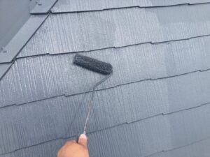 屋根にグレーのペンキで上塗り塗装