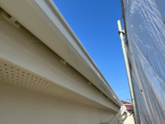 ローラーで白く塗装された世田谷区の住宅の雨樋
