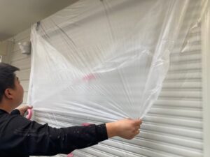 武蔵野市 シャッターが閉まった窓に養生をしている職人