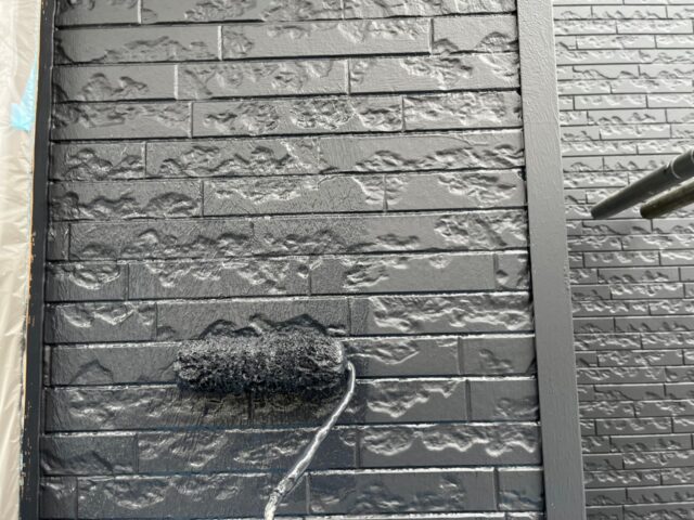 ローラーで上塗りをされる世田谷区の住宅の外壁