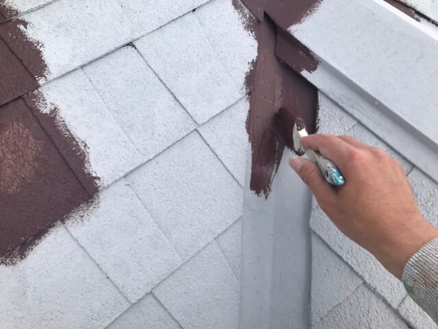 ハケで丁寧に塗り込まれる三鷹市の住宅の屋根