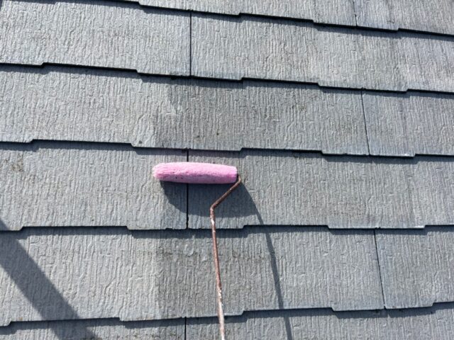 ローラーで塗装される調布市の住宅の屋根