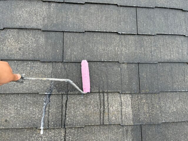 ローラーで下塗りされる世田谷区の住宅の屋根