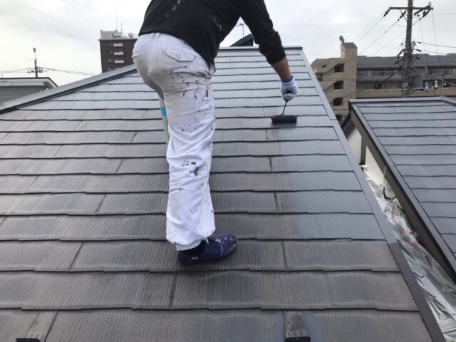 職人によって下塗りをされる三鷹市の住宅の屋根