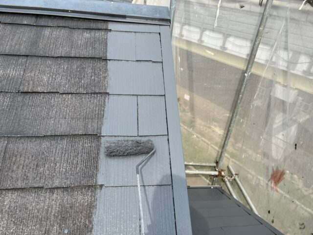 ローラーで中塗りされる調布市の住宅の屋根