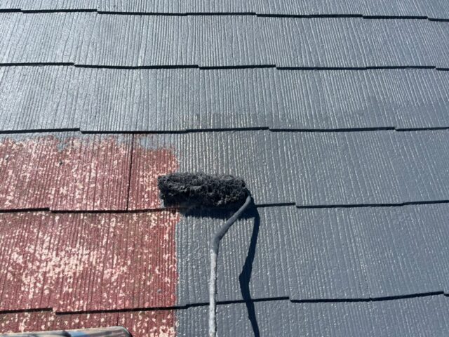 ローラーで丁寧に塗装される三鷹市のアパートの屋根