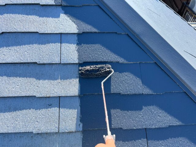ローラーで塗装される調布市の住宅の屋根