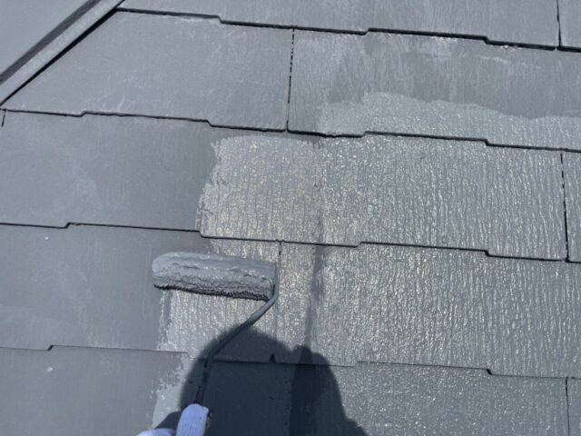 ローラーで上塗りされる世田谷区の住宅の屋根