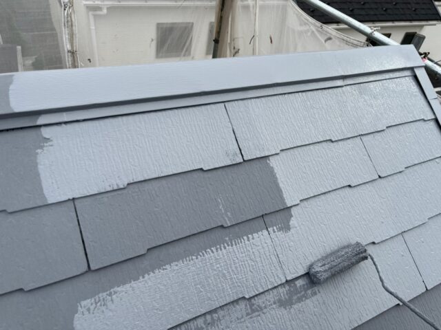ローラーで上塗りされる三鷹市の住宅の屋根