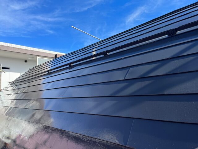 ローラーで綺麗に黒に塗装された調布市の住宅の屋根